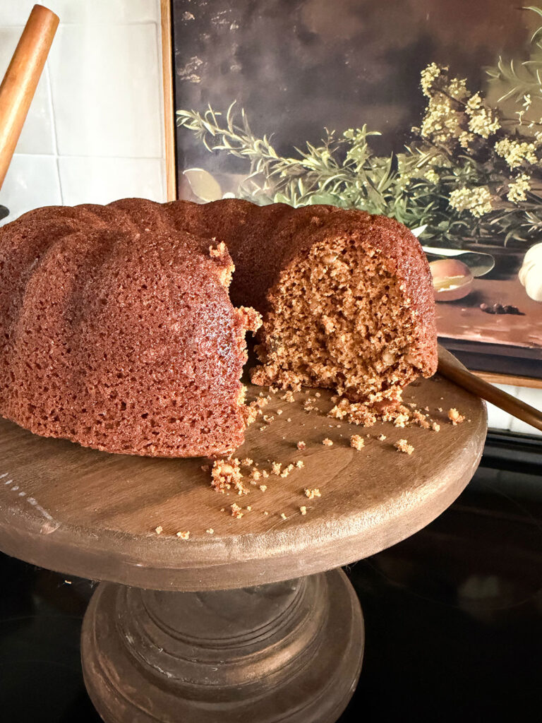applesauce cake with slice removed on wooden cake stand
