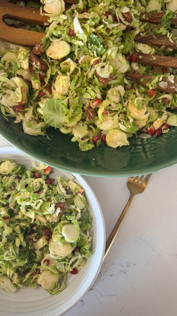 serving dish of salad with smaller white bowl of salad next to it with gold fork