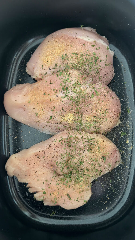 seasoned raw chicken breasts in crockpot