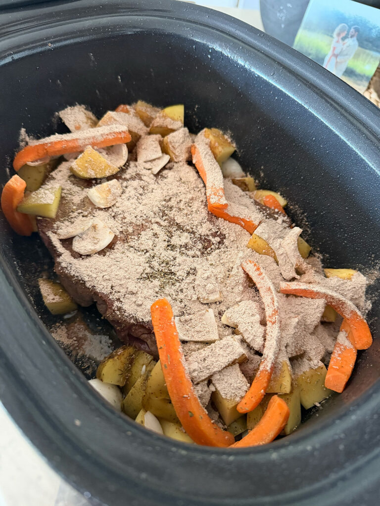 meat, veggies and seasoning in slow cooker