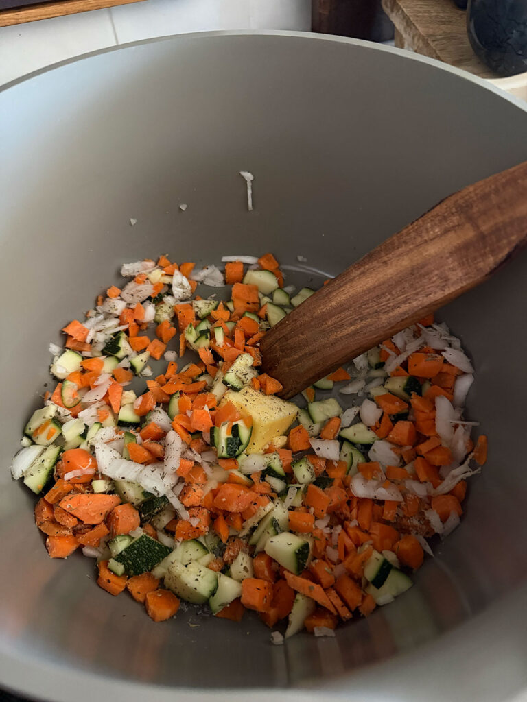 vegetables in pot with wooden spoon