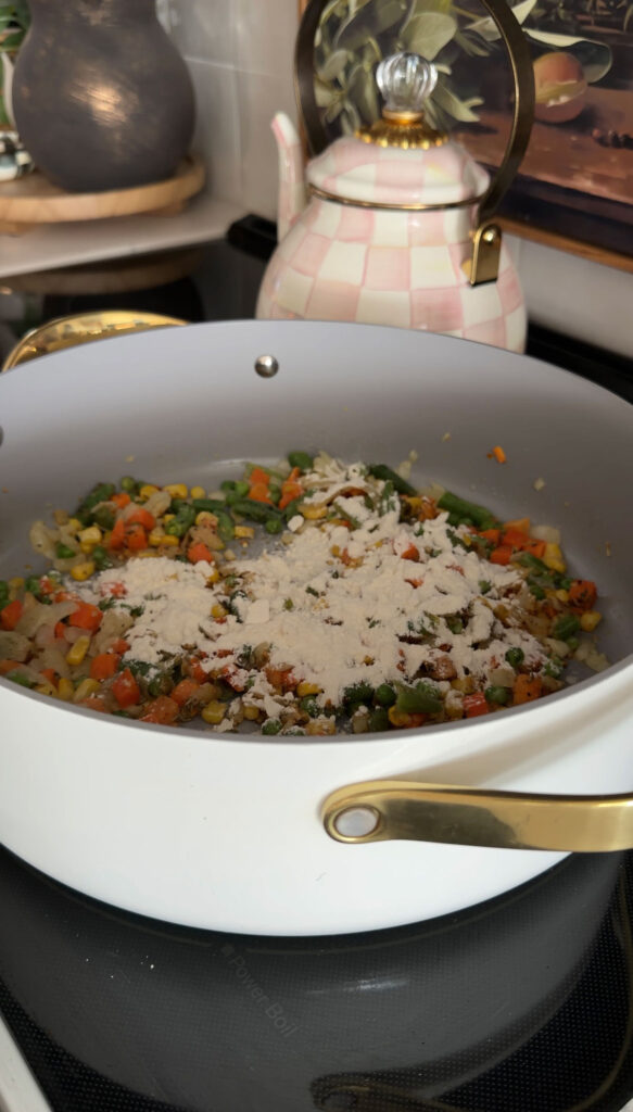 flour added to veggies in pot