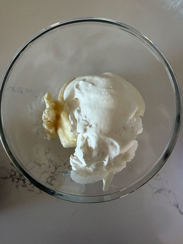 pudding and whipped topping mixture in clear bowl