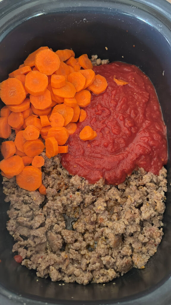 browned sasusage, carrots and tomato sauce in slow cooker