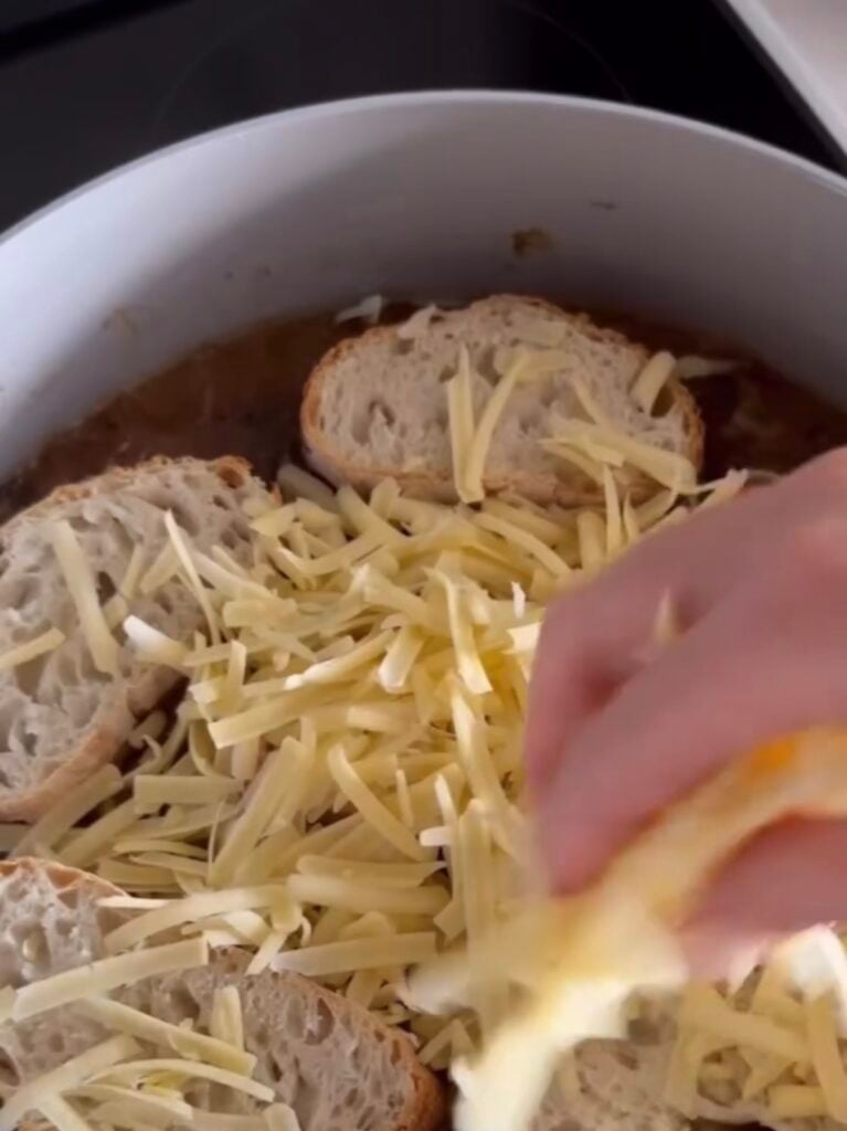 hand sprinkling on cheese over bread slices