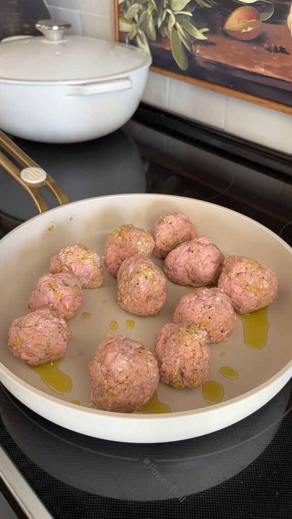 A skillet with chicken parm meatballs.
