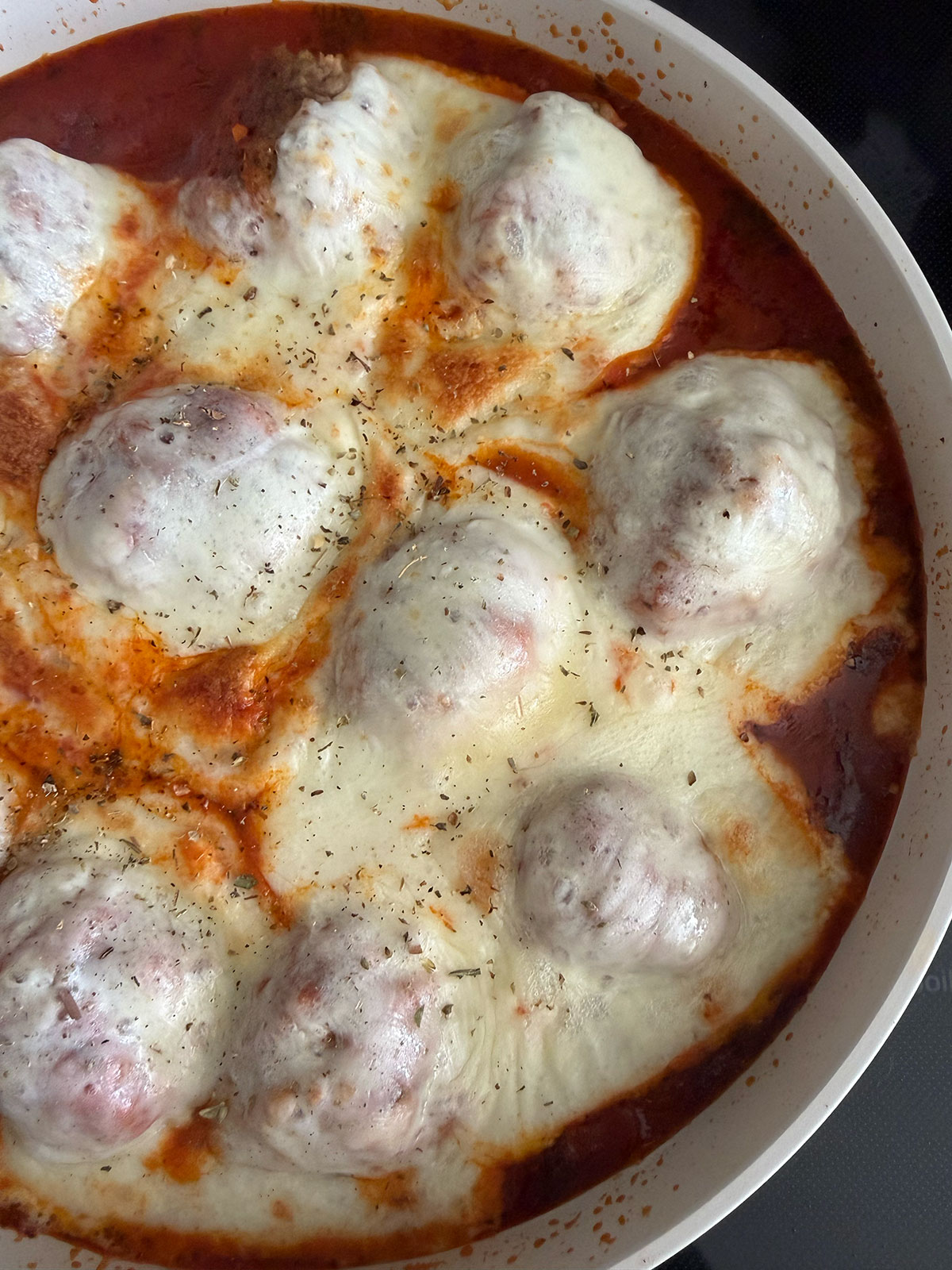 Chicken parm meatballs with melted cheese on top.