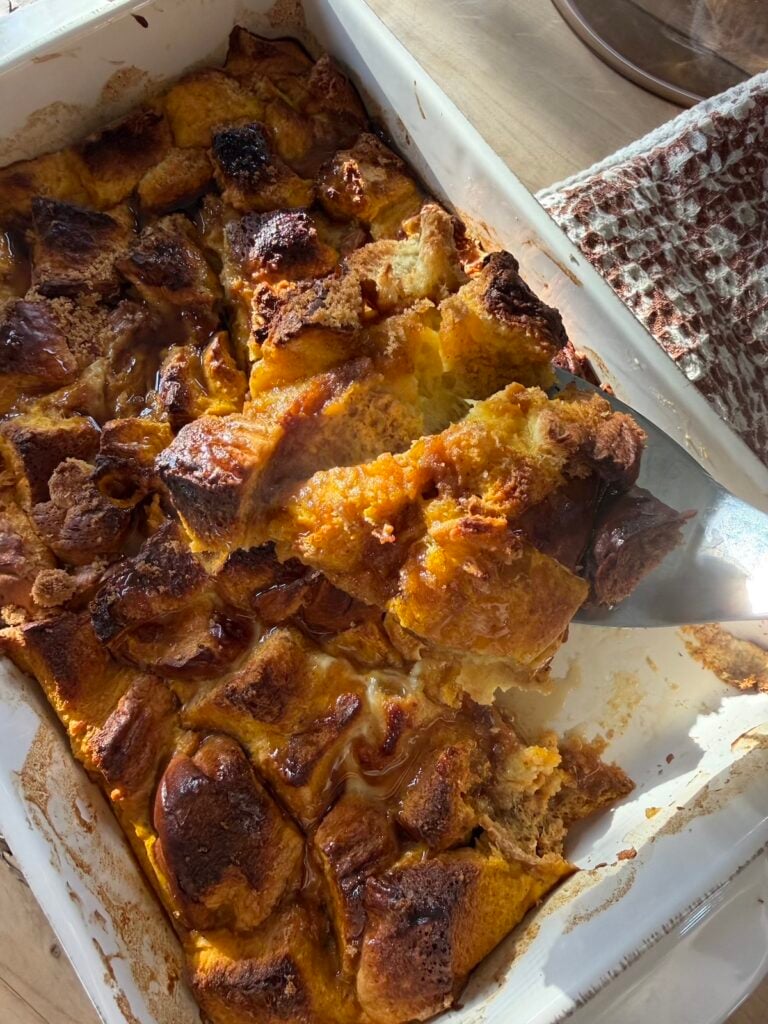 A spatula taking a scoop out of pumpkin french toast casserole.